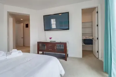 a bedroom with a bed and a tv on the wall at Rooftop Patio Hot Tub AC Beach & Bay Views in San Diego