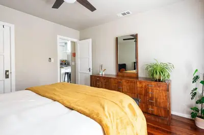a bedroom with a bed with a dresser and a mirror at Charming Mid-Century Craftsman, Hot Tub with Serene Yard in San Diego