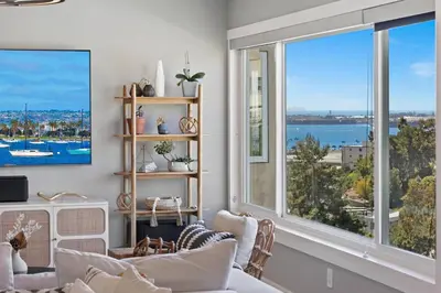 a living room with two couches and a large window at Ventana Vista, Ocean View in San Diego