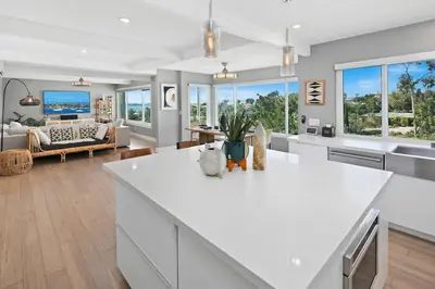 a kitchen and living room with a white counter top at Ventana Vista, Ocean View in San Diego