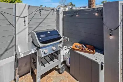 a grill sitting on a patio next to a fence at Ventana Vista, Ocean View in San Diego