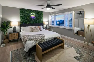 a bedroom with a large bed with a green wall at Ventana Vista, Ocean View in San Diego