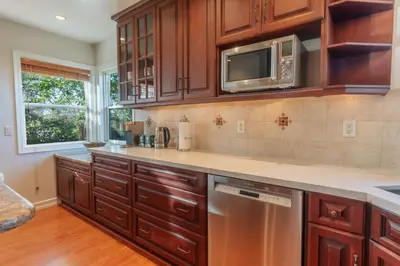 a kitchen with wooden cabinets and a microwave at Family-Friendly Bay Views, Game Room, Hot Tub! in San Diego
