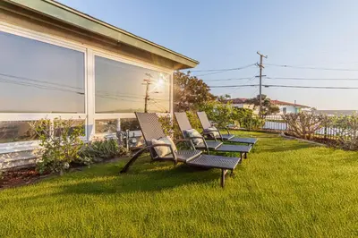 a row of chairs sitting on a lawn next to a house at Family-Friendly Bay Views, Game Room, Hot Tub! in San Diego