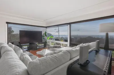 a living room with a large couch and a flat screen tv at Family-Friendly Bay Views, Game Room, Hot Tub! in San Diego