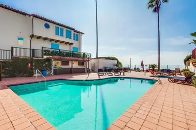 a swimming pool in front of a building at Ocean Views Moonlight Beach Ocean Deck Pool Hot Tub in Encinitas