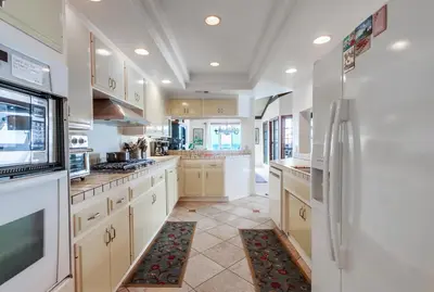 a large kitchen with white cabinets and appliances at Ocean Views Moonlight Beach Ocean Deck Pool Hot Tub in Encinitas