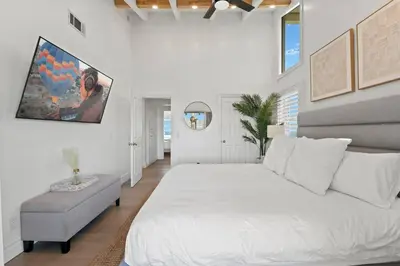 a white bedroom with a large bed and a chair at Above the Clouds 17acre Gated Hilltop Estate in Fallbrook