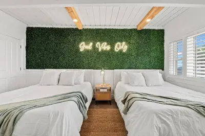 two beds in a room with a green wall at Above the Clouds 17acre Gated Hilltop Estate in Fallbrook