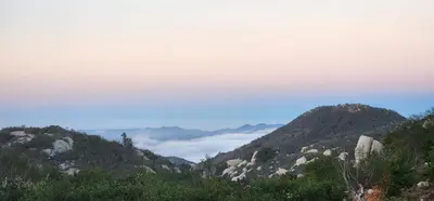 a view of a mountain with clouds in the distance at Gentle and Cozy Comfort in an Off-Grid Retreat in Fallbrook