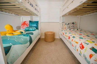 two bunk beds in a room with two beds at 2 private masters, new beds & furniture, sleeps 12 in San Diego