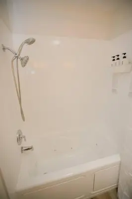 a shower in a bathroom with a white wall at 2 private masters, new beds & furniture, sleeps 12 in San Diego