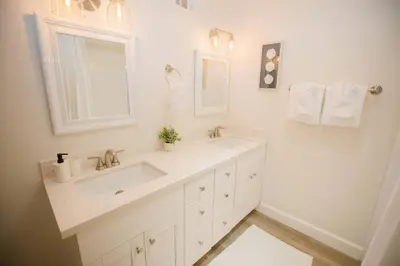 a white bathroom with two sinks and a mirror at 2 private masters, new beds & furniture, sleeps 12 in San Diego