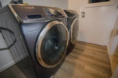 a washing machine in a room with a door at 2 private masters, new beds & furniture, sleeps 12 in San Diego