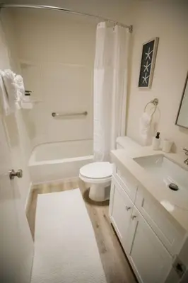 a white bathroom with a toilet and a sink at 2 private masters, new beds & furniture, sleeps 12 in San Diego