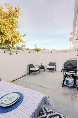 a patio with a table and chairs and a fence at King Suite - Steps to Beach & Close to Pier in Oceanside