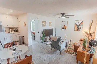 a living room with a table and a kitchen at Steps to Beach & Close to Restaurants and Shops in Oceanside