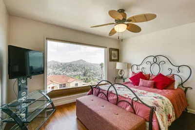 a bedroom with a bed and a large window at Mt Nebo Oasis in La Mesa with Wraparound Deck in La Mesa