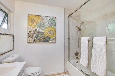 a white bathroom with a shower and a toilet at Mt Nebo Oasis in La Mesa with Wraparound Deck in La Mesa