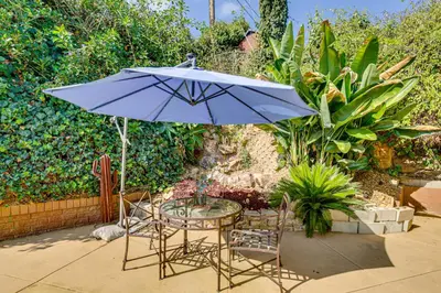 a table and chairs with an umbrella on a patio at Mt Nebo Oasis in La Mesa with Wraparound Deck in La Mesa