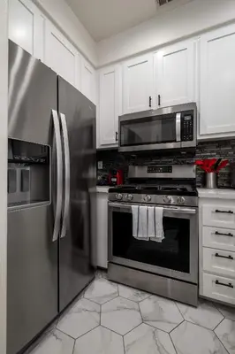a kitchen with stainless steel appliances and white cabinets at Redecorated - Serene- Legoland- Family-Friendly in Carlsbad