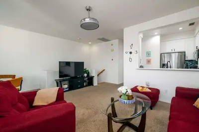 a living room with two red couches and a glass table at Redecorated - Serene- Legoland- Family-Friendly in Carlsbad