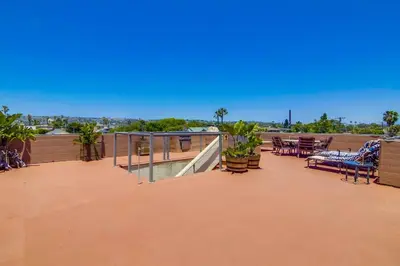 a patio with chairs and tables on a roof at PACIFIC BEACH ESTATE water view in San Diego