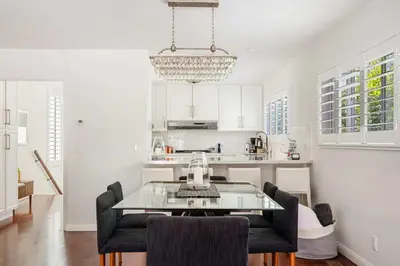 a white kitchen with a glass table and chairs at Luxury La Jolla Home with Jacuzzi in San Diego