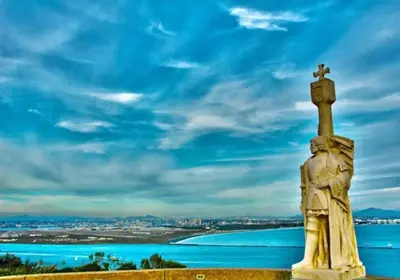 a statue with a cross on top of it next to the water at Majestic Lux Home with Heated Pool and Spa! in San Diego