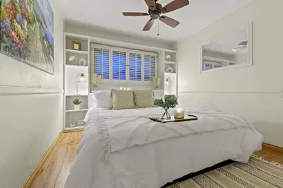 a white bedroom with a large bed and a ceiling fan at Majestic Lux Home with Heated Pool and Spa! in San Diego
