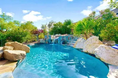 a pool with a waterfall and rocks in a backyard at Massive 7BR Stunning MTN View Zen Retreat Pool and Spa in Ramona