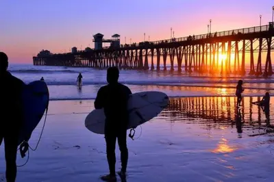 a group of people walking on the beach with surfboards at MB Contemporary 14 Guests by Sand AC plus Garage in San Diego