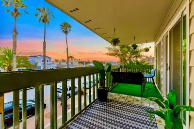 a balcony with a view of the beach and palm trees at 1 Block to Sand Stylish 3BR Contemporary Home in San Diego