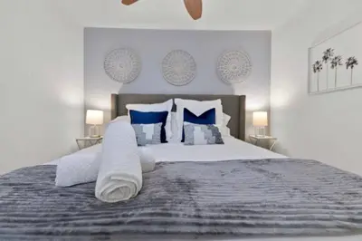 a bedroom with a large bed with blue and white pillows at 1 Block to Sand Stylish Boho Retreat in San Diego