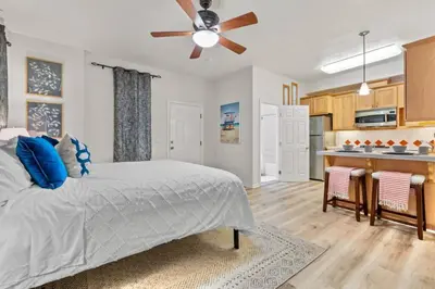 a bedroom with a bed and a ceiling fan at 1 Block to the Sand Stylish & Spacious Studio! in San Diego
