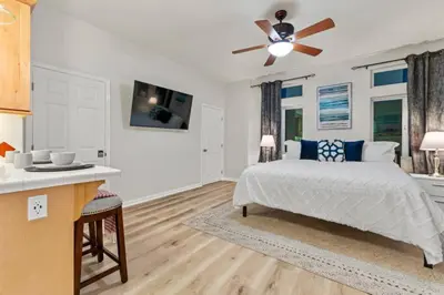 a bedroom with a bed and a ceiling fan at 1 Block to the Sand Stylish & Spacious Studio! in San Diego