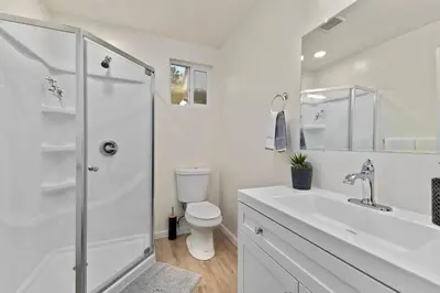 a white bathroom with a toilet and a shower at PB 3BR Beach Retreat Hot Tub Mini Golf in San Diego