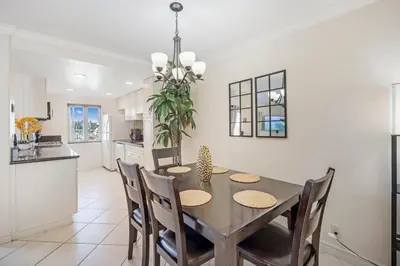 a kitchen and dining room with a table and chairs at Serene Harborfront Condo | Unbeatable Views & Coastal Charm in Oceanside