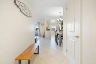 a hallway with a bench and a dining room at Serene Harborfront Condo | Unbeatable Views & Coastal Charm in Oceanside