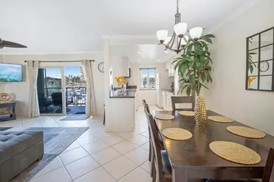 a dining room and living room with a dining table at Serene Harborfront Condo | Unbeatable Views & Coastal Charm in Oceanside