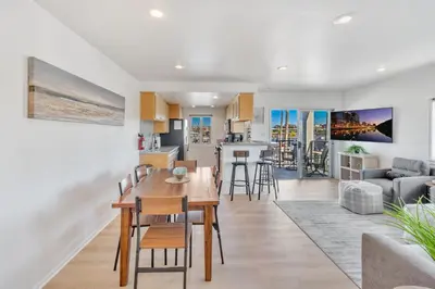 a kitchen and living room with a table and chairs at Oceanside Harbor Getaway | Steps to Sand, Shops & Restaurants in Oceanside