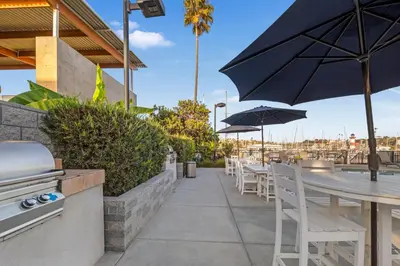 a restaurant with tables and chairs and an umbrella at Oceanside Harbor Getaway | Steps to Sand, Shops & Restaurants in Oceanside