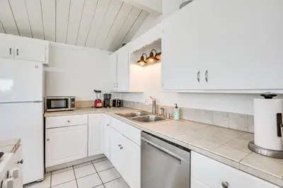 a kitchen with white cabinets and a sink at 3 Mi to Balboa Park Water-View Condo with Balcony in San Diego