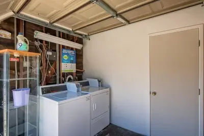 a laundry room with a washing machine and a door at Walk to Beach - KING Apt In #1 Area - AB in San Clemente