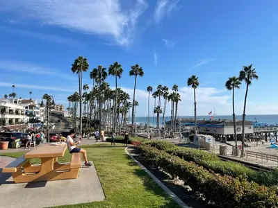 a woman sitting on a bench near the beach at Walk to Beach - KING Apt In #1 Area - AB in San Clemente