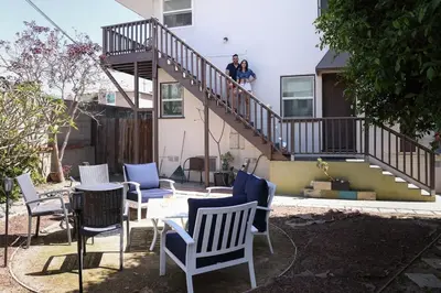 two people standing on the stairs of a house at Walk to Beach - KING Apt In #1 Area - AC in San Clemente