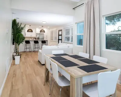 a dining room and living room with a table and chairs at Newly Built Coastal Home with Yard in San Diego