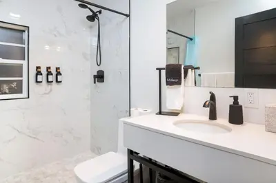 a white bathroom with a sink and a shower at Newly Built Coastal Home with Yard in San Diego