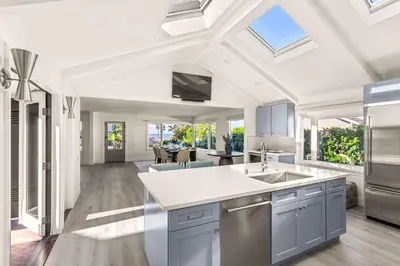 an open kitchen and living room with a vaulted ceiling at Pacific Perfection - Ocean Views Jacuzzi Walk to Beach and Dining in San Diego