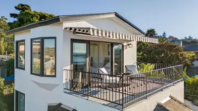 a house with a balcony with a table and chairs at Pacific Perfection - Ocean Views Jacuzzi Walk to Beach and Dining in San Diego
